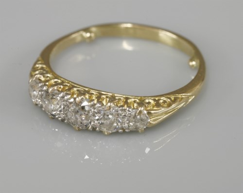 Lot 1039 - A five stone graduated diamond carved head ring