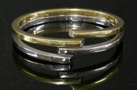 Lot 276 - A two-colour gold hinged bangle