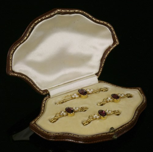 Lot 94 - An Edwardian cased set of four almandine garnet and split pearl gold bar brooches