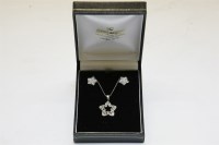 Lot 73 - A pendant and earring suite comprising of a white gold channel set diamond star pendant