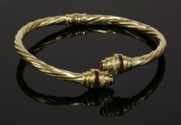Lot 28 - An Italian ruby and cubic zirconia hinged crossover bangle