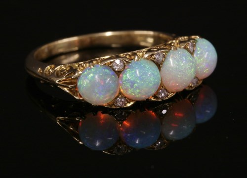 Lot 41 - A four stone opal and diamond carved head ring