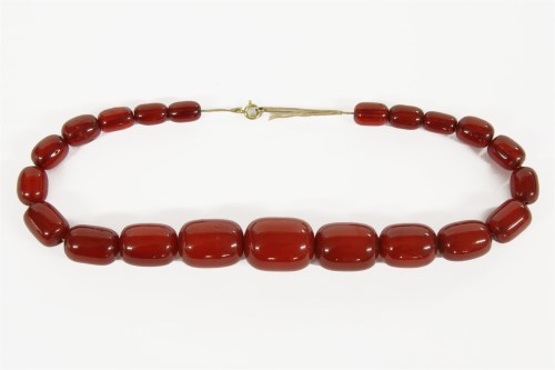 Lot 17 - A single row graduated cherry coloured barrel shaped Bakelite beads