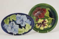 Lot 1221 - Two Moorcroft 'Hibiscus' dishes. an oval blue ground dish with green monogram 23cm long and a circular dish