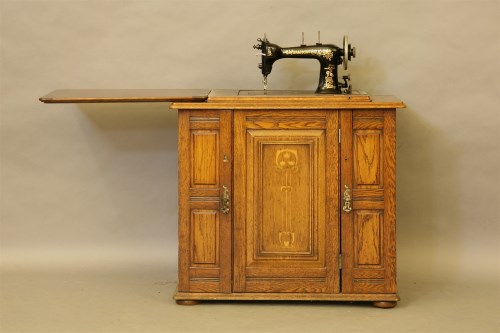 Lot 487 - A sewing machine and cabinet