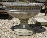 Lot 1053 - A Large reconstituted stone garden urn with incised decoration and on circular spreading base