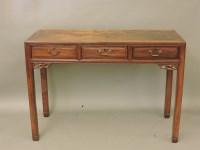 Lot 730 - A Chinese hardwood three drawer side table