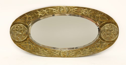 Lot 65 - An Arts & Crafts embossed oval brass mirror
