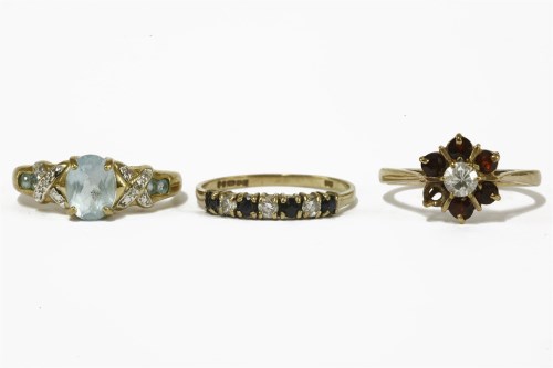 Lot 19 - A 9ct gold oval cut topaz ring with diamond and topaz set shoulders