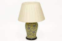 Lot 368 - A large oriental yellow ceramic vase lamp-base with blue scrolling detail and a cream satin shade on wood plinth