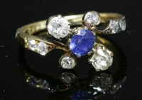 Lot 79 - An Art Nouveau sapphire and diamond crossover ring with an oval mixed cut sapphire