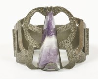Lot 55 - A 1974 triangular cabochon amethyst bangle with pierced top section