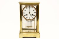 Lot 299 - An early 20th century brass and four glass mantel clock