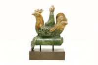 Lot 111 - A 19th century Chinese pottery figural ridge tile in the form of a man riding on a cockerel