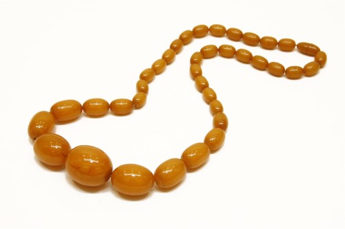 Lot 1075 - A single row graduated butterscotch egg-yolk olive-shaped Bakelite bead necklace