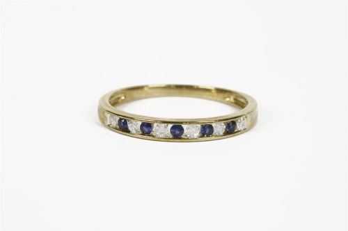 Lot 1081 - A sapphire and diamond channel set half eternity ring