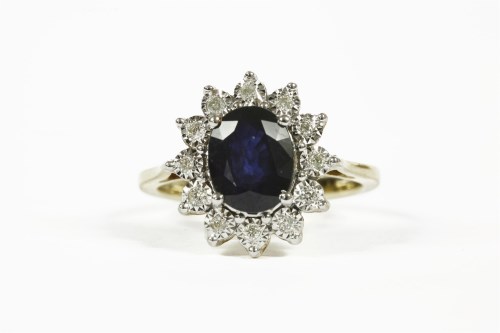 Lot 1093 - A 9ct gold sapphire and diamond oval cluster ring