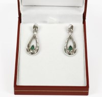 Lot 1074 - A pair of white gold emerald and diamond pear shaped drop earrings