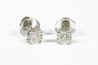Lot 1080 - A pair of illusion set single stone diamond stud earrings