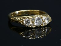 Lot 70 - An 18ct gold three stone diamond carved head-style ring