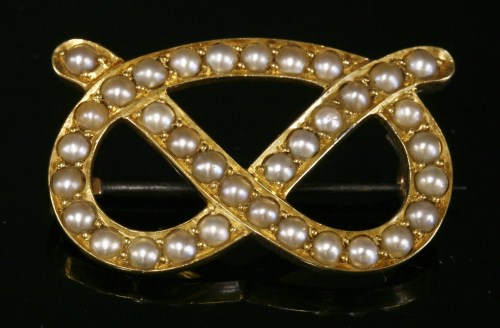 Lot 95 - A gold split pearl overhand knot brooch