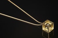 Lot 703 - An 18ct gold single stone diamond perspex cube pendant