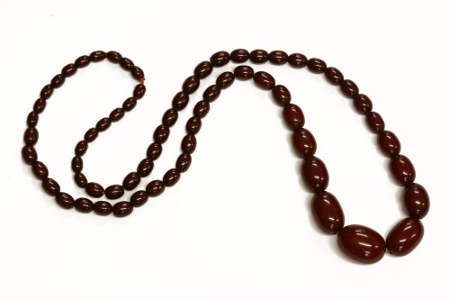 Lot 88 - A single row graduated cherry coloured olive shaped Bakelite bead necklace