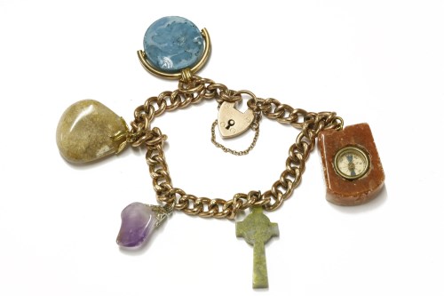 Lot 46 - A gold curb link bracelet with padlock and assorted hardstone charms
