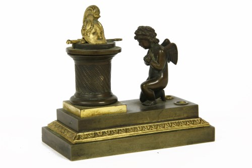 Lot 140 - A 19th century bronze desk stand in the form of a putti kneeling at a monument