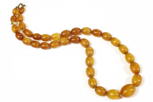 Lot 43 - A single row graduated olive shaped amber bead necklace
17.56g