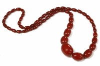 Lot 49 - A single row graduated cherry coloured olive shaped Bakelite bead necklace