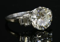 Lot 155 - A single stone diamond ring with stepped baguette cut diamond shoulders
