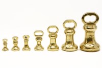 Lot 115 - A partial set of brass bell weights
