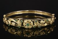 Lot 713 - A 9ct gold emerald set hinged bangle