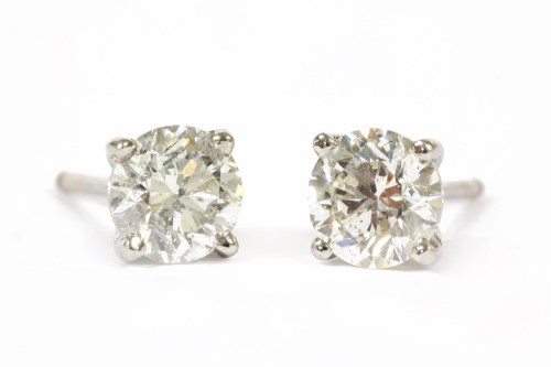 Lot 144 - A pair of white gold single stone diamond stud earrings