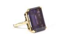 Lot 114 - A gold single stone emerald cut synthetic colour change sapphire ring