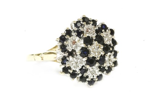 Lot 121 - A 9ct gold diamond and sapphire four tier cluster ring