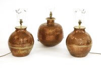 Lot 396 - A pair of planished copper table lamps