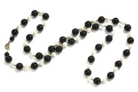 Lot 58 - A single row uniformed round shaped onyx and Baroque shaped cultured pearl  necklace