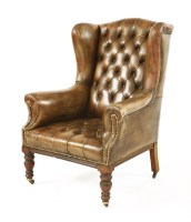 Lot 950 - A leather wing-back armchair