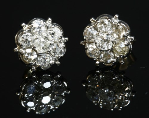 Lot 257 - A pair of seven stone diamond daisy cluster stud earrings