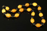 Lot 659 - A single row two colour amber bead necklace