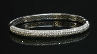 Lot 456 - A white gold diamond set hinged bangle