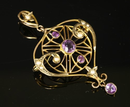 Lot 108 - An Edwardian Art Nouveau amethyst and split pearl brooch/pendant