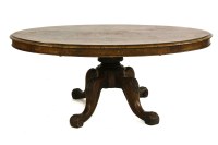 Lot 947 - A Victorian walnut coffee table (reduced from a loo table) the oval top on turned column and four scroll legs