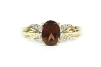 Lot 229 - A gold single oval cut garnet ring with diamond set shoulders