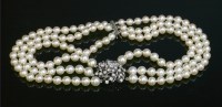 Lot 283 - A three row graduated cultured pearl necklace with a diamond set cluster centrepiece