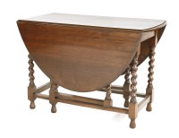 Lot 1108 - An oak gate leg table with barley twist supports