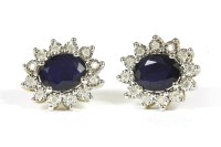 Lot 242 - A pair of sapphire and diamond oval cluster earrings