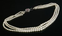 Lot 265 - A three row graduated cultured pearl necklace with a diamond and ruby cluster clasp